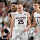 Teammates flank CJ Fleming (front) after he hits a game-winning shot against Jacksonville.